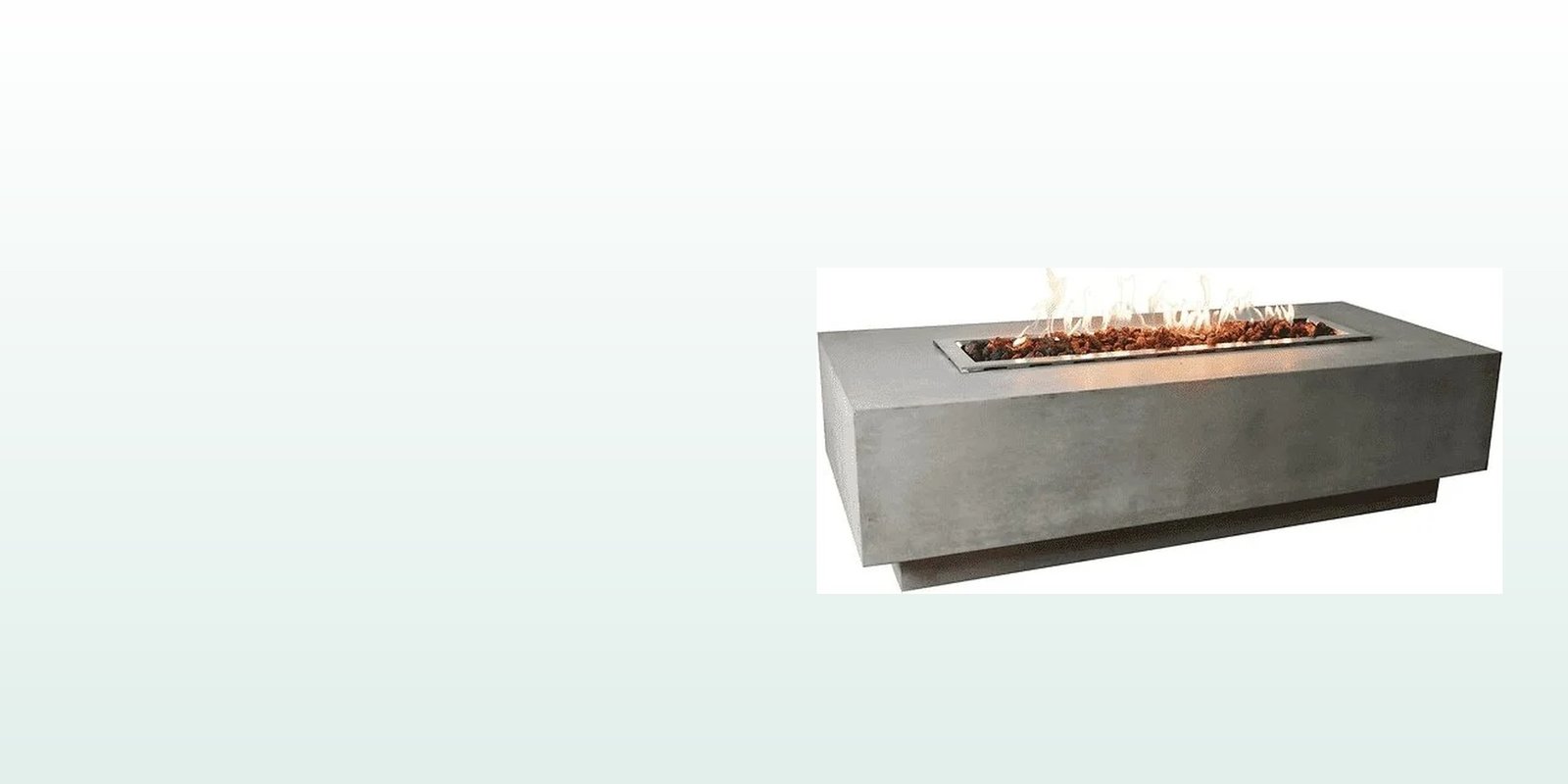 A concrete fire pit table with flames rising, on a calm evening